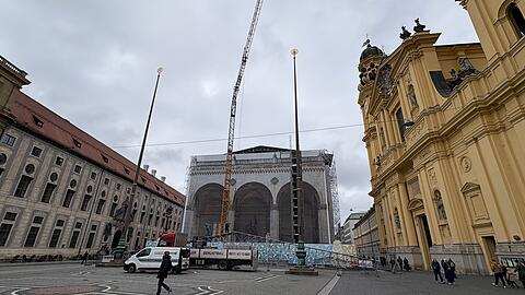 Mit einem Baukran wird die provisorische Dachabdeckung auf der Feldherrnhalle kompletiert.