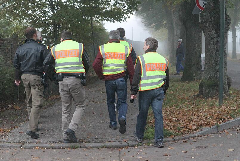 Polizisten kontrollieren in Augsburg die Zufahrt der Sportanlage Sued, nachdem in der Nacht zu Freitag ein Polizist bei einer Verfolgungsfahrt in Augsburg erschossen wurde.