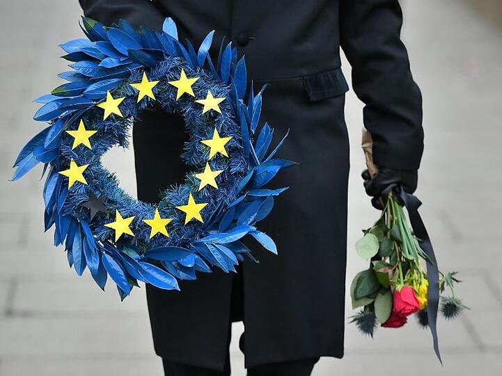 Ein als Leichenbestatter verkleideter Mann trägt einen Kranz mit 11 anstatt der bisher 12 Sterne der EU-Flagge über den Parlamentsplatz in London.