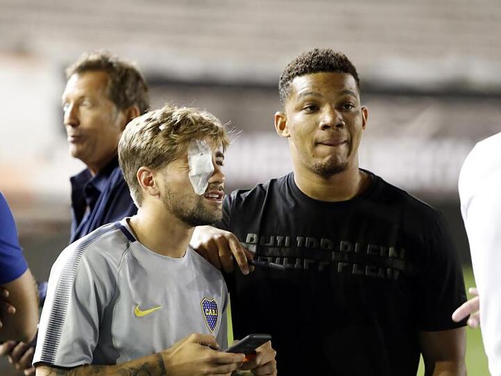 Die Spieler der Boca Juniors stehen nach der Verlegung auf dem Spielfeld. Mehrere von ihnen wurden verletzt als ihr Bus mit Steinwürfen angegriffen wurde.