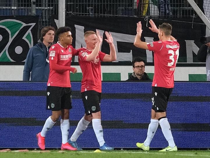 Hannovers Philipp Ochs (M) bejubelt sein Tor zum 2:1 gegen Holstein Kiel mit Linton Maina und Waldemar Anton (r).