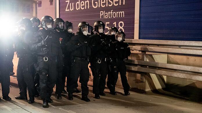 Polizisten mit Helmen und Schlagstöcken.