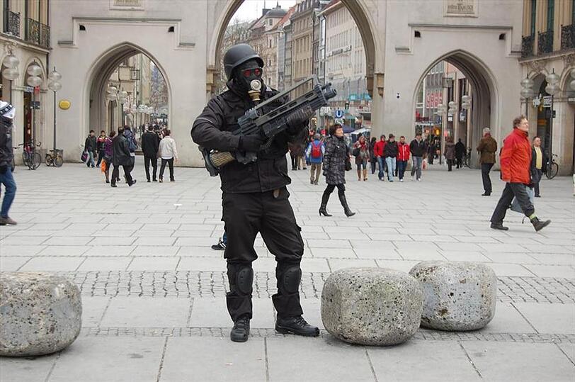 Fragwürdige PR-Aktion für ein Computerspiel: Ein Mann im Kampfanzug fuchtelt mit einer Spielzeug-MG herum. Die Polizei rückt an.