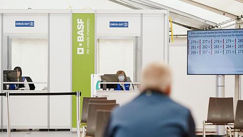 Ein geimpfter Mitarbeiter sitzt im BASF-Impfzentrum im Wartebereich, in dem mögliche Nebenwirkungen der Corona-Impfung beobachtet werden.