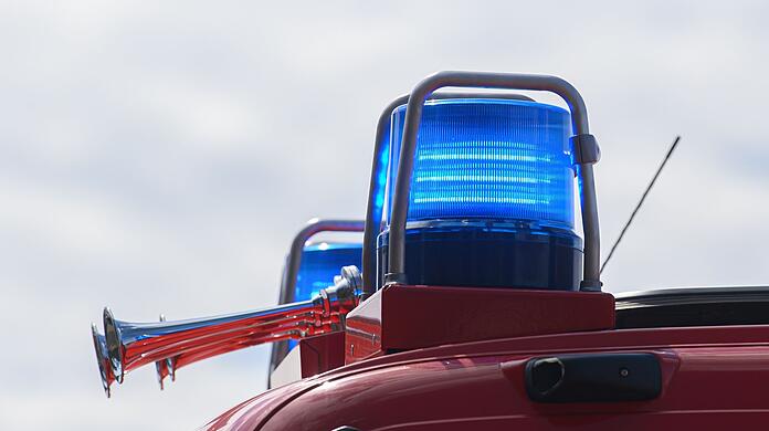Blaulichter leuchten auf dem Dach eines Einsatzfahrzeugs der Feuerwehr.