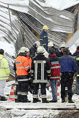 Rettungskräfte tragen am 4. Januar 2006 in den Trümmern der eingestürzten Eishalle im Bad Reichenhall einen Holzsarg.