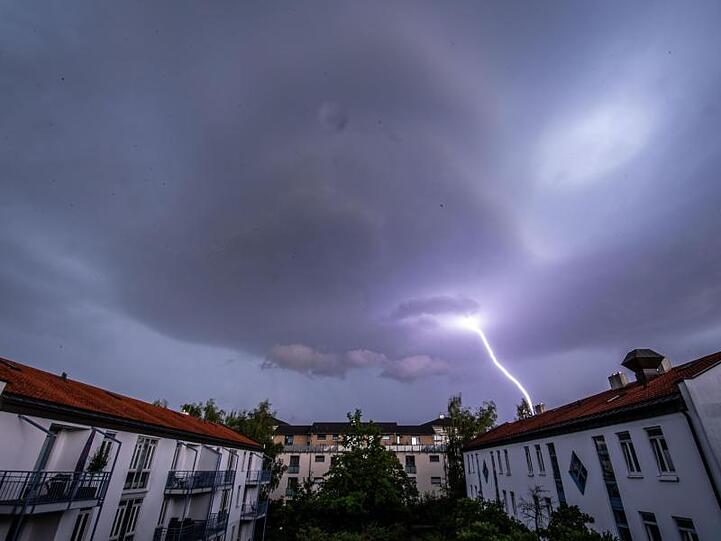 Ein Blitz schlägt in der Ferne ein. Foto: Lino Mirgeler/dpa/Archivbild