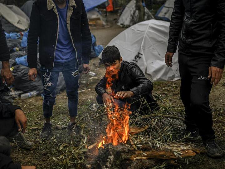 Migranten versuchen sich an einem kleinen Feuer neben dem Lager Moria auf der Insel Lesbos aufzuwärmen.