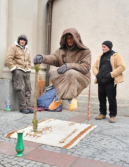 Er schaut selten auf und hält mit ruhiger Hand einen Stock.