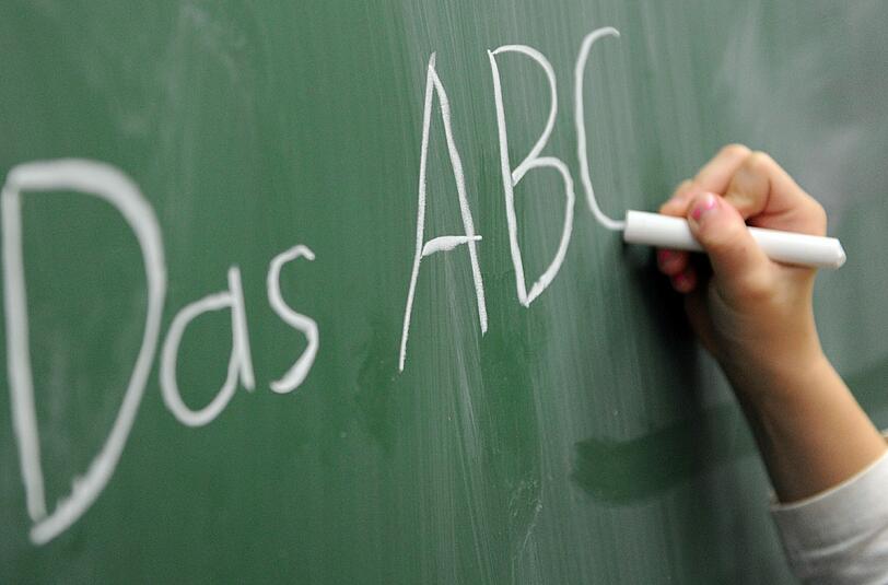 Rechtschreibexperte Christian Stang schreibt das Wort Rechtschreibung auf eine Tafel. Der Deutsche Philologenverband kritisiert, dass Schülerinnen und Schüler zu wenig lesen und daher keine Rechtschreibkompetenz erwerben. Foto: Daniel Reinhardt