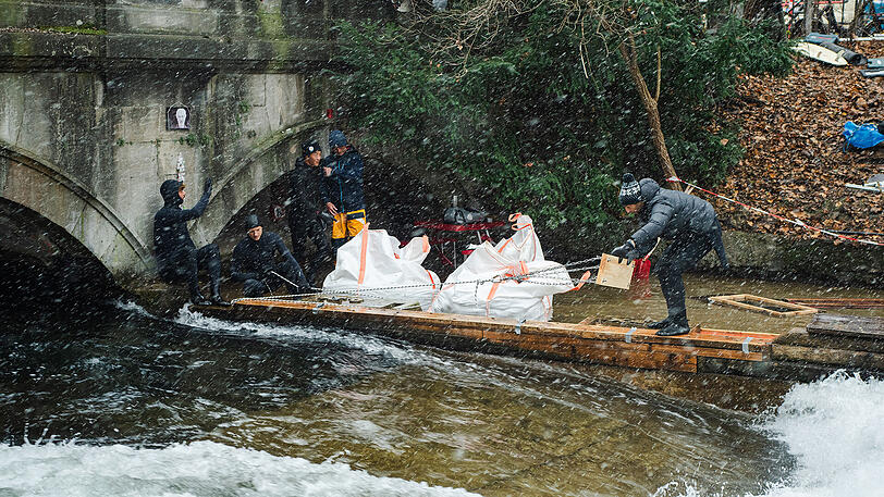 Bei Schneefall wurde ein Rettungsversuch der Eisbachwelle mit Kies gestartet.