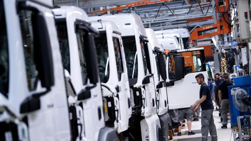 Mitarbeiter von MAN Truck & Bus arbeiten an einer Produktionsstraße an einem LKW.