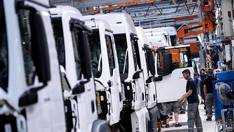 Mitarbeiter von MAN Truck & Bus arbeiten an einer Produktionsstraße an einem LKW.