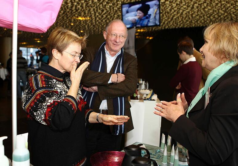 Franz Maget sieht beim Handcreme-Testen zu.
