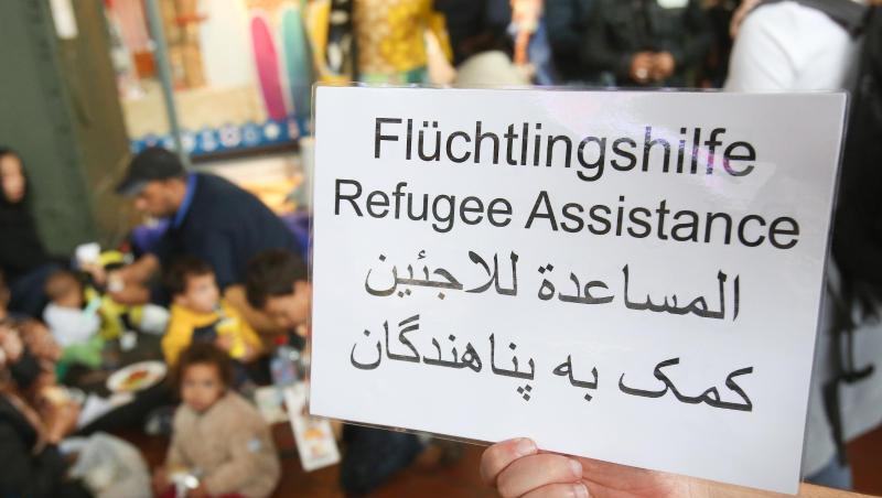 Ein freiwilliger Helfer hält 2015 im Hauptbahnhof in Hamburg ein Schild auf deutsch, englisch und arabisch, auf der Hilfe für Flüchtlinge angeboten wird. Ein freiwilliger Helfer hält 2015 im Hauptbahnhof in Hamburg ein Schild auf deutsch, englisch und arabisch, auf der Hilfe für Flüchtlinge angeboten wird.