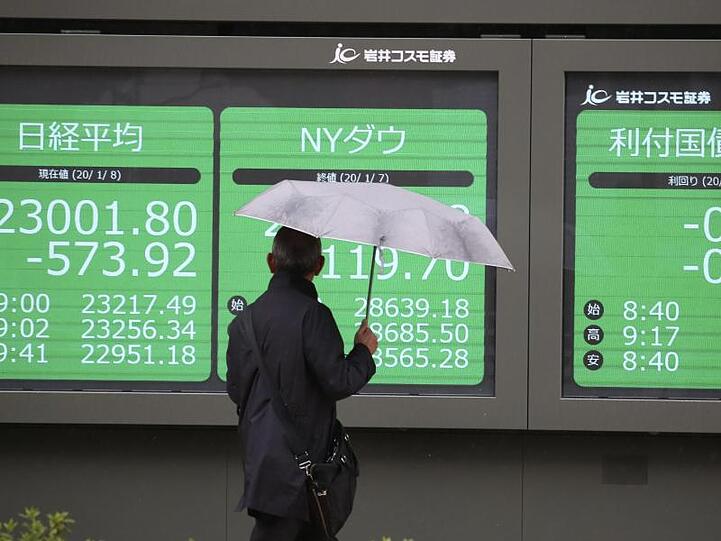 Eine Mann betrachtet eine elektronische Anzeigetafel in Tokio, auf der die Börsenwerte angezeigt werden.