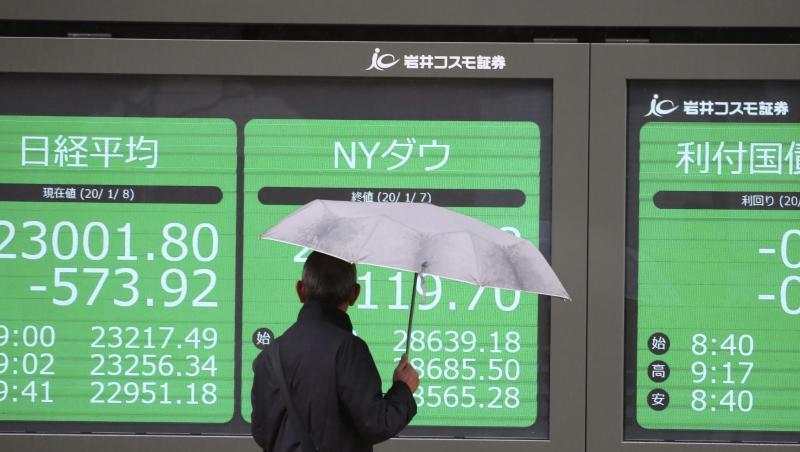 Eine Mann betrachtet eine elektronische Anzeigetafel in Tokio, auf der die Börsenwerte angezeigt werden. Eine Mann betrachtet eine elektronische Anzeigetafel in Tokio, auf der die Börsenwerte angezeigt werden.