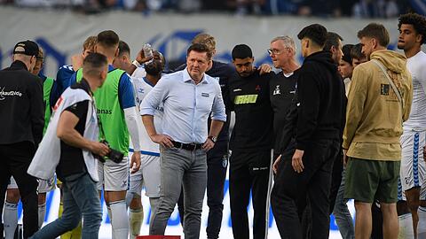 Magdeburgs Trainer Christian Titz steht nach dem Spiel bei seinen Spielern auf dem Feld.