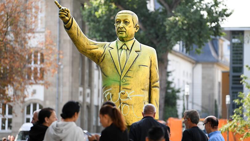 Wiesbaden: Passanten stehen auf dem Platz der Deutschen Einheit vor einer goldenen Erdogan-Statue. Sie wurde im Rahmen des Kunstfestivals "Wiesbaden Biennale" aufgestellt. Wiesbaden: Passanten stehen auf dem Platz der Deutschen Einheit vor einer goldenen Erdogan-Statue. Sie wurde im Rahmen des Kunstfestivals "Wiesbaden Biennale" aufgestellt.