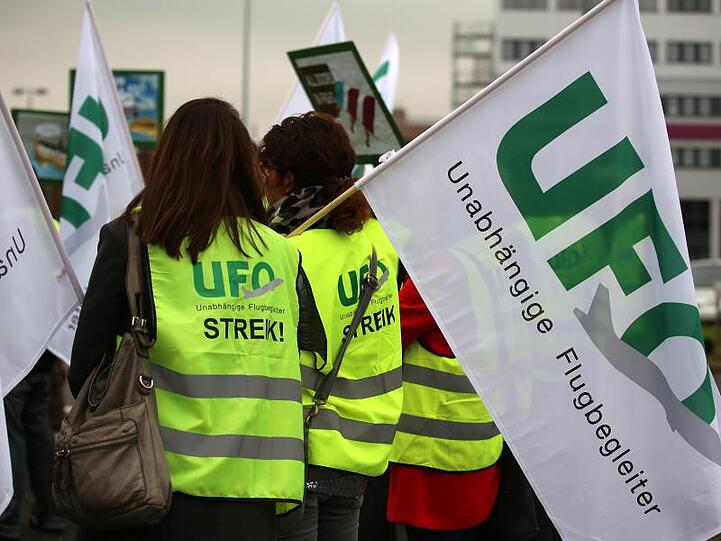 Flugbegleiter von Lufthansa-Töchtern Eurowings und Germanwings stehen mit Fahnen der Gewerkschaft UFO (Unabhängige Flugbegleiter Organisation) bei einer Kundgebung vor der Unternehmenszentrale.