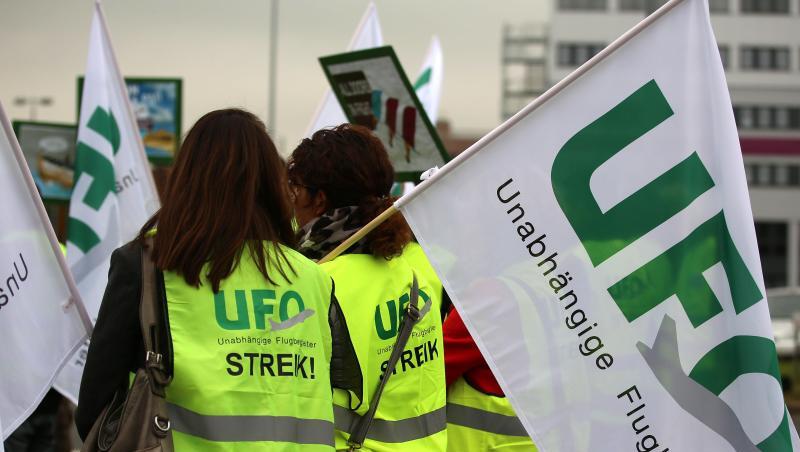 Flugbegleiter von Lufthansa-Töchtern Eurowings und Germanwings stehen mit Fahnen der Gewerkschaft UFO (Unabhängige Flugbegleiter Organisation) bei einer Kundgebung vor der Unternehmenszentrale. Flugbegleiter von Lufthansa-Töchtern Eurowings und Germanwings stehen mit Fahnen der Gewerkschaft UFO (Unabhängige Flugbegleiter Organisation) bei einer Kundgebung vor der Unternehmenszentrale.