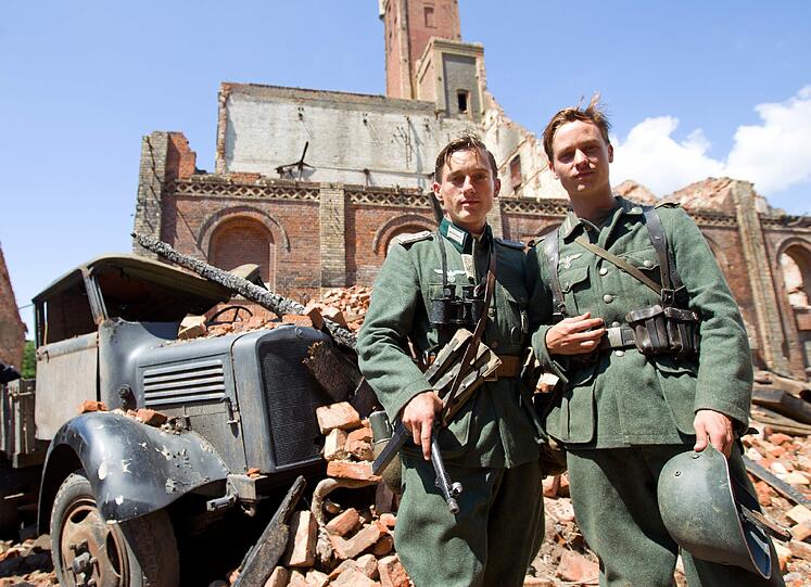 Der Schauspieler Volker Bruch (l) in der Rolle des Wilhelm Winter und der Schauspieler Tom Schilling als sein Bruder Friedhelm Winter - zwei tragende Rollen im ZDF-Dreiteiler.