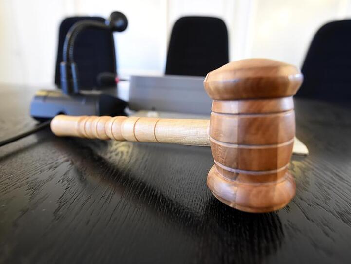 Auf der Richterbank liegt ein Richterhammer aus Holz. Foto: picture alliance / Uli Deck/dpa/Symbolbild