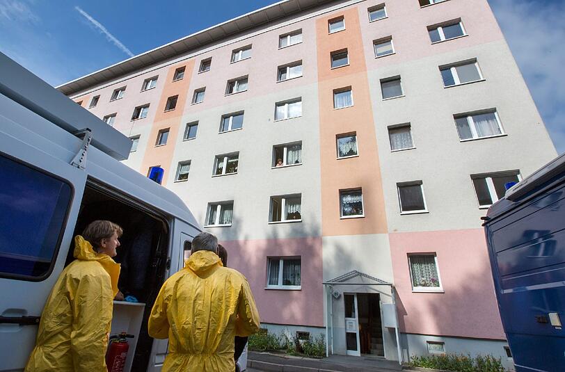 Mitarbeiter der Spurensicherung gehen am 27.08.2013 in den Eingang eines Hauses in einer Plattenbausiedlung in Suh. Hier wurden am Dienstagmorgen zwei Kinderleichen gefunden. Bilder vom Tatort.