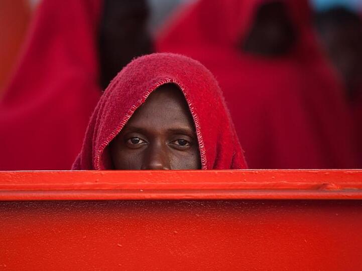 Und was kommt nun? Ein afrikanischer Migrant wartet in eine Decke gehüllt nach seiner Ankunft im Hafen von Malaga.