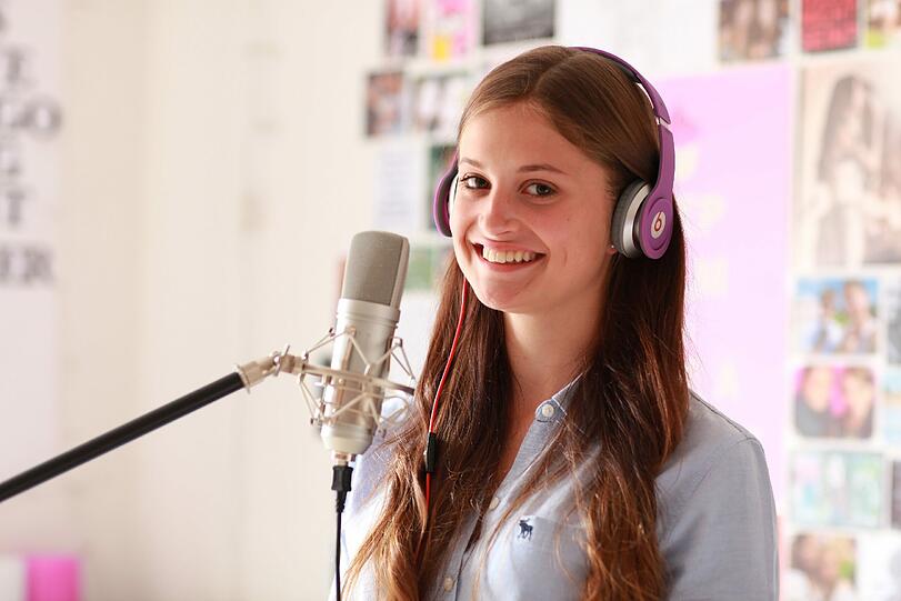 Grinsekatze am Mikrofon: In ihrem Zimmer nimmt die 17-Jährige Coverversionen von bekannten Songs auf und lädt sie ins Internet.