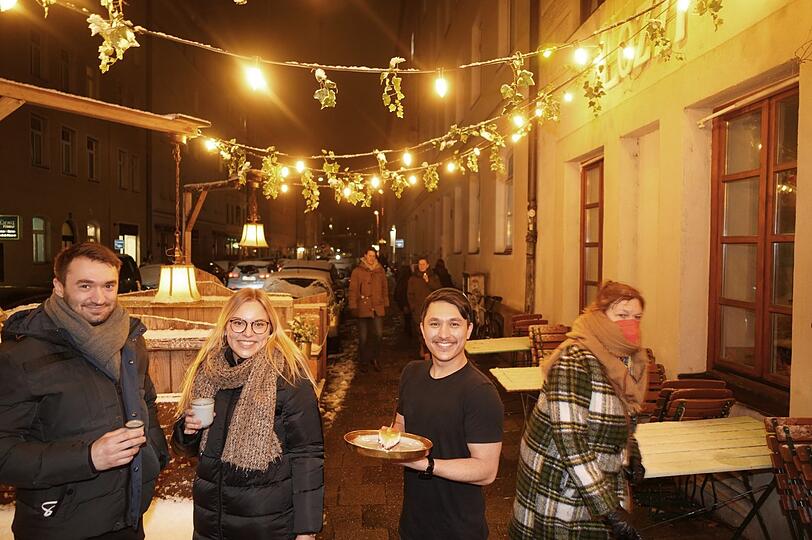 Januar in München: Die Pestalozzistraße ist verschneit, die Lichterkette funkelt, Amelie und Ralf wärmen sich an ihren Heißgetränken und der Gute-Laune-Stimmung vorm Café Lozzi. Kalt? Ah geh. Dominik, eigentlich Motiondesigner, bringt den Kuchen im T-Shirt.