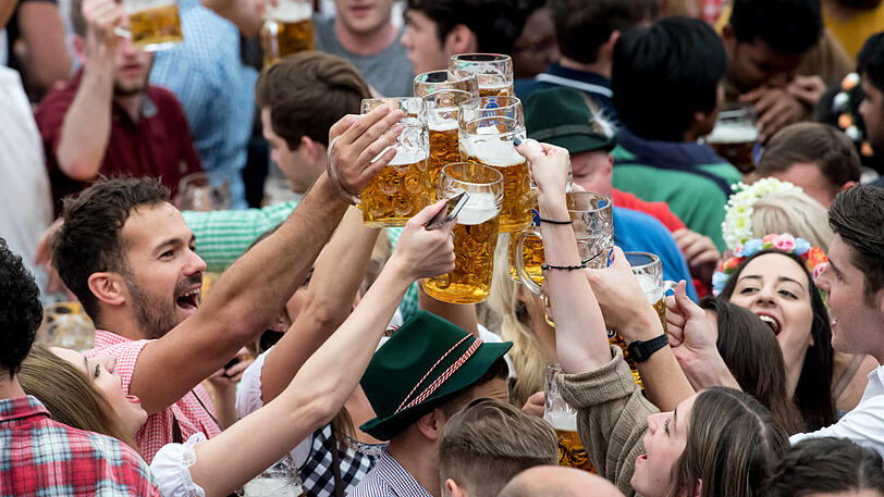 Wiesn-Besucher stoßen im Hofbräu-Zelt miteinander an. Hier gibt es seit diesem Jahr CO2-neutrales Bier.