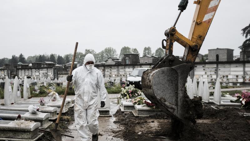 Ein Mitarbeiter im Schutzanzug geht in der Industriestadt Turin über einen Friedhof, auf dem frische Gräber ausgehoben werden. Ein Mitarbeiter im Schutzanzug geht in der Industriestadt Turin über einen Friedhof, auf dem frische Gräber ausgehoben werden.