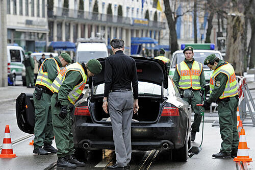 Polizeibeamte kontrollieren ein Auto am Bayerischen Hof