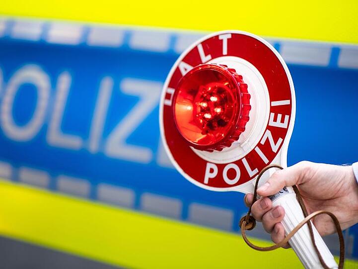 Ein Polizist bittet um Anhalten. Foto: Marius Becker/dpa/Symbolbild