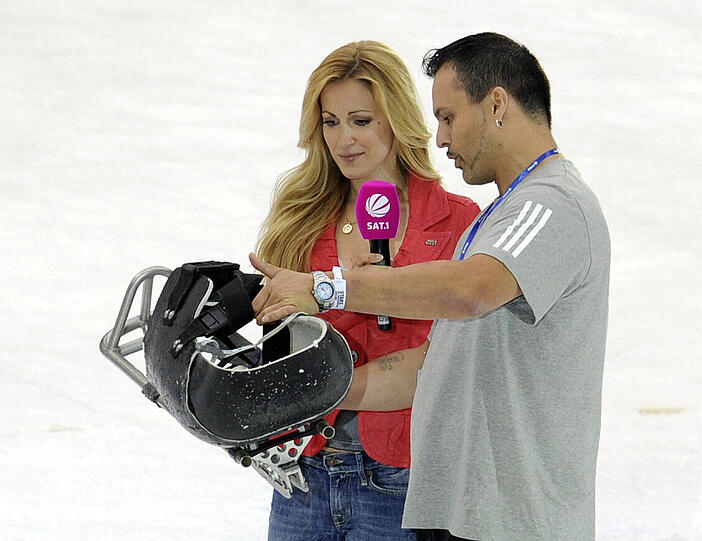 Eishockey-Athlet Jörg Wedde zeigt Moderatorin Andrea Kaiser sein Equippment.