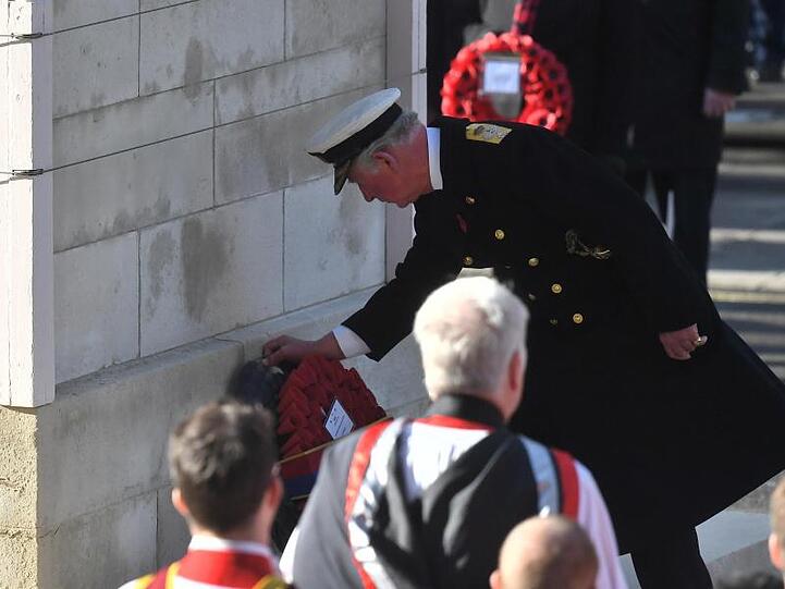 Prinz Charles legt einen Kranz aus roten Mohnblüten nieder.