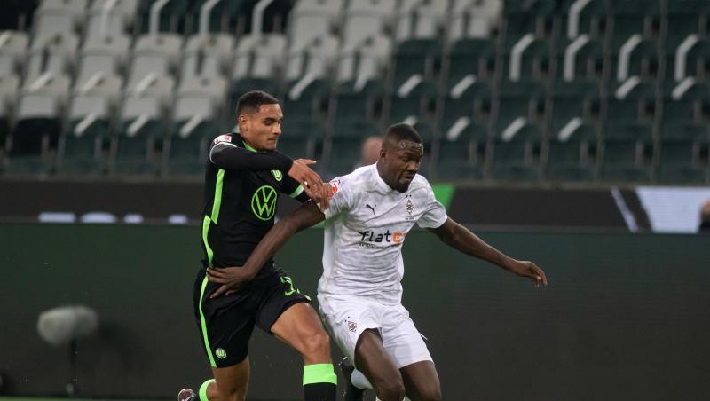 Mönchengladbachs Marcus Thuram (r) im Laufduell mit Wolfsburgs Maxence Lacroix.