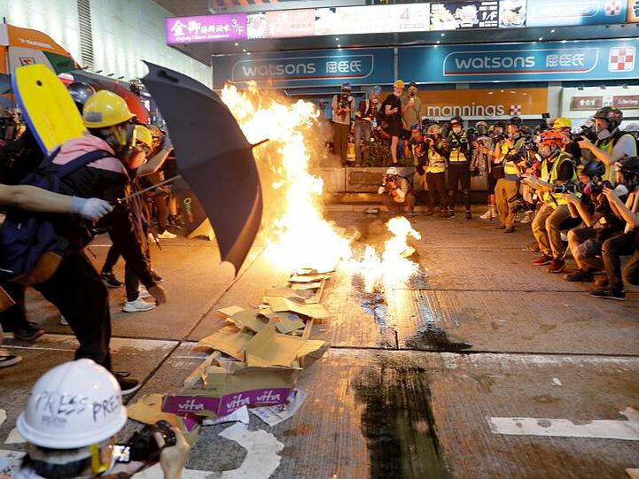 Demonstranten verbrennen Karton, um eine Barriere zu bilden. Die Polizei setzte Tränengas ein und räumte Straßen.