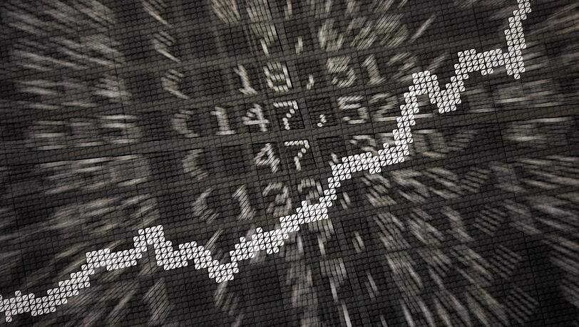 Die große Anzeige in der Börse zeigt die Dax-Kurve und verschiedene Börsenkurse: ETFs werden börsentäglich gehandelt.