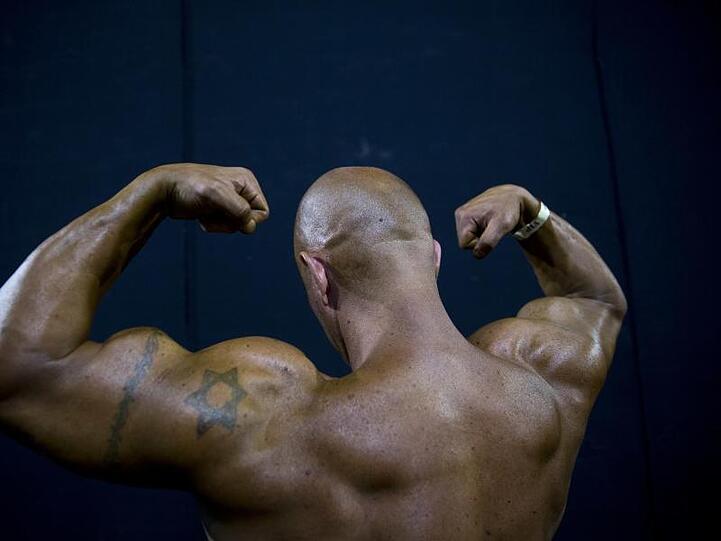 Ein Bodybuilder spannt die Muskeln. Foto: Oded Balilty/AP/Archiv