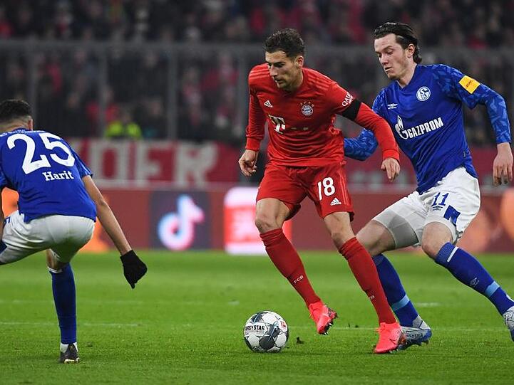 Bayerns Leon Goretzka kämpft gegen Schalkes Amine Harit und Michael Gregoritsch um den Ball. Foto: Angelika Warmuth/dpa