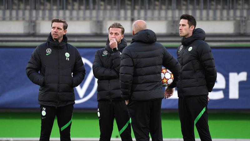 Vor dem Abflug nach Sevilla war Corona wieder ein Thema: Wolfsburgs Trainer Florian Kohfeldt (l) steht mit seinem Team zusammen.
