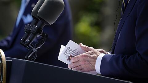 US-Präsident Joe Biden schaut während der Pressekonferenz im Rosengarten des Weißen Hauses auf seine Notizen.
