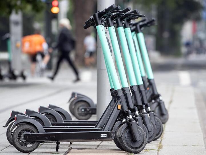 E-Tretroller stehen am Straßenrand und warten auf Kunden.