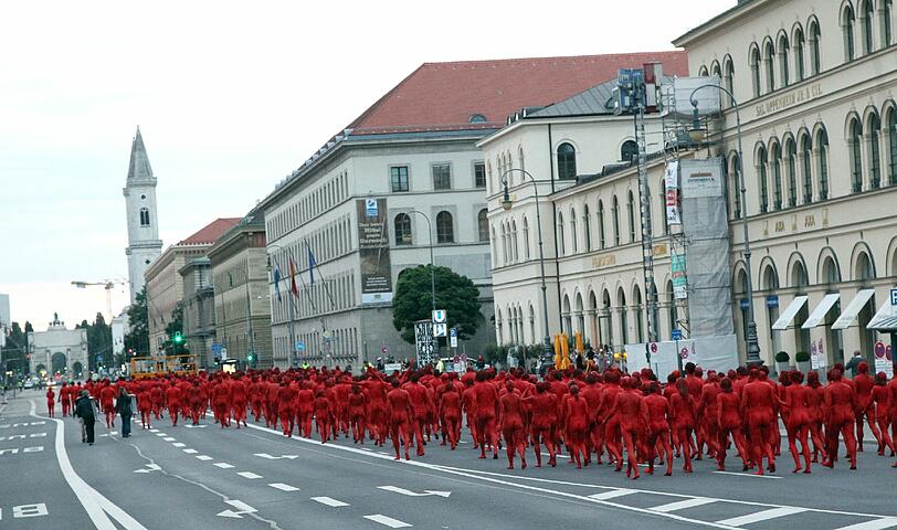 Star-Fotograf Spencer Tunick lässt zur Eröffnung der Opernfestspiele für seine Installation hunderte bunt angemalte Menschen durch München laufen. Das Highlight: Die rot-goldenen Teilnehmer stellen sich an Münchner Monumenten entlang der Ludwigstraße auf. Hier gibts die Bilder!