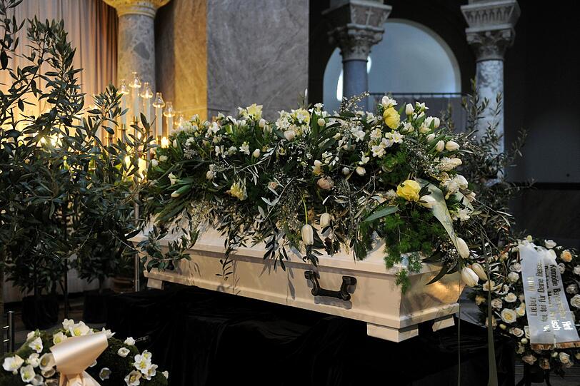 Ein Meer von Blumen über Jopies weißem Sarg.