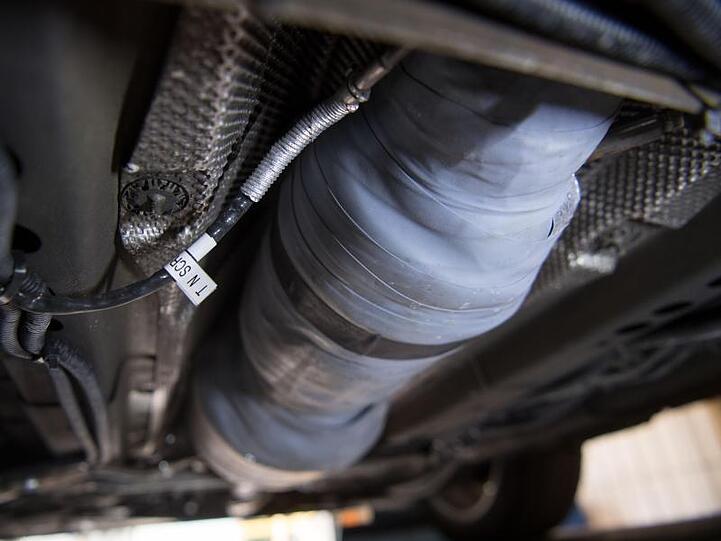 Ein nachgerüsteter SCR-Katalysator ist am Unterboden eines umgerüsteten Opel Astra zu sehen.