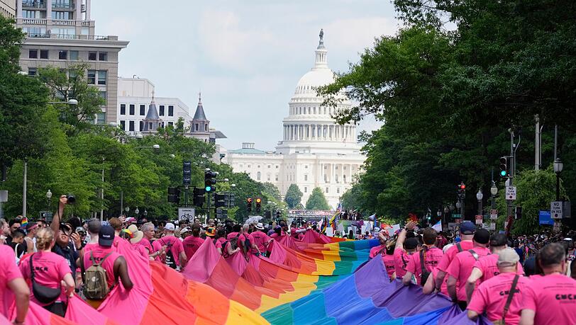 Mit riesigen Regenbogenfahnen demonstrieren Menschen mit Blick auf das US-Kapitol bei einer Pride-Parade in Washington für die Rechte der LGBTQI+-Gemeinschaft.