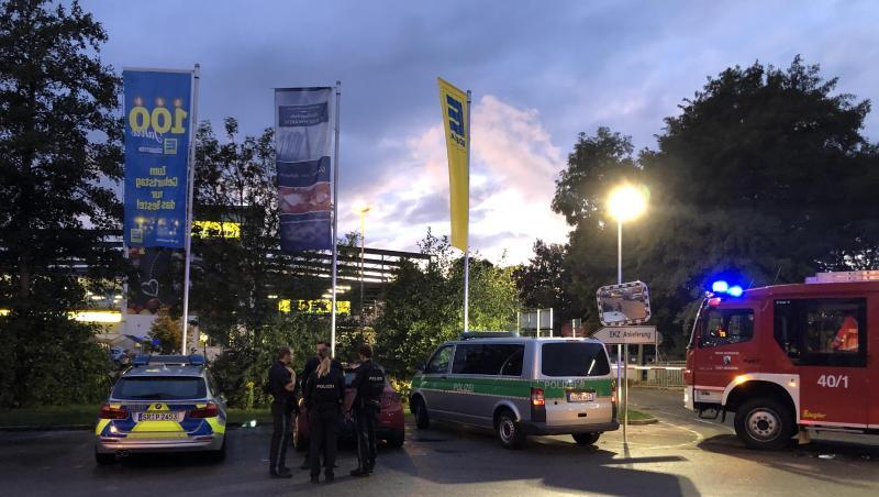 Fahrzeuge von Polizei und Feuerwehr stehen vor einem Supermarkt in dem Schüsse gefallen sind. Foto: Alexander Auer/dpa